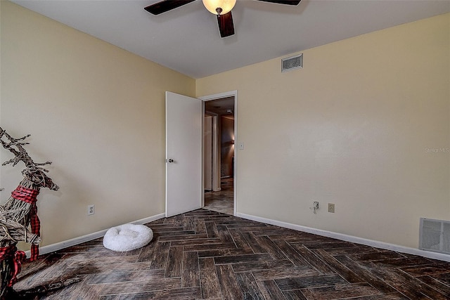 empty room with dark parquet flooring and ceiling fan