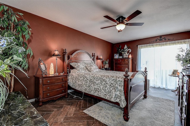 bedroom featuring ceiling fan, dark parquet flooring, and a textured ceiling