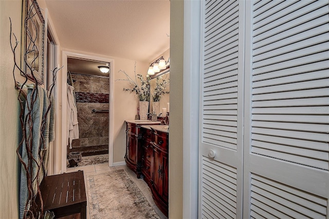 bathroom featuring vanity, a textured ceiling, and walk in shower