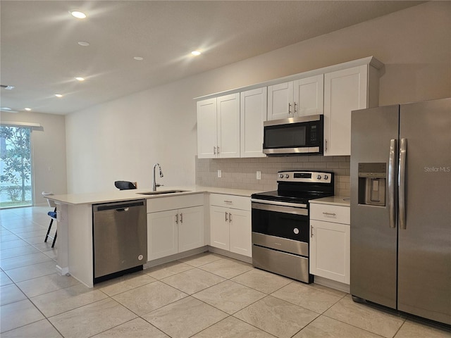 kitchen with white cabinetry, appliances with stainless steel finishes, and kitchen peninsula