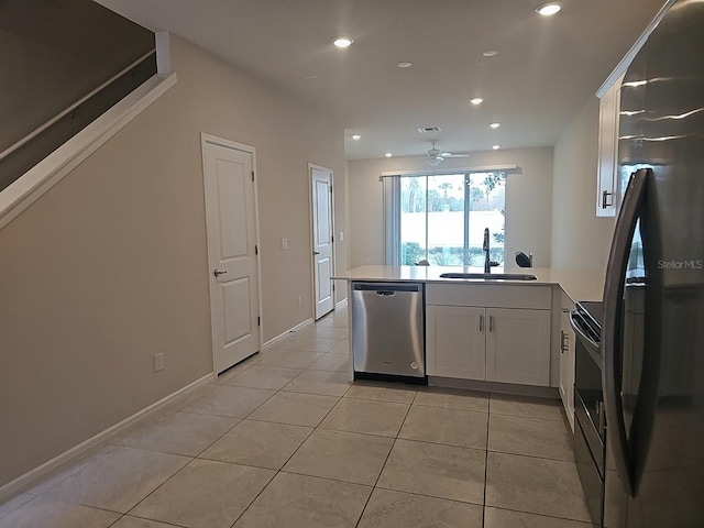 kitchen featuring sink, white cabinetry, light tile patterned floors, fridge, and stainless steel dishwasher