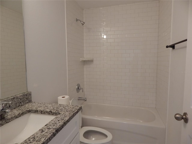 full bathroom featuring tiled shower / bath, vanity, and toilet