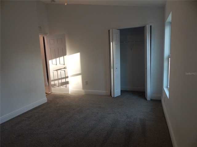 unfurnished bedroom with lofted ceiling, a closet, and carpet flooring