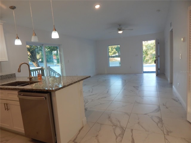 kitchen with sink, hanging light fixtures, white cabinets, stainless steel dishwasher, and dark stone counters