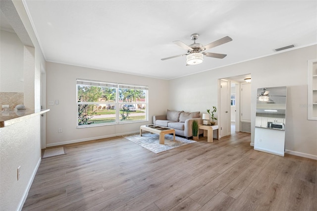 unfurnished living room with light hardwood / wood-style flooring, ornamental molding, and ceiling fan