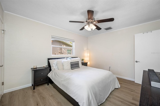 bedroom featuring ornamental molding, a textured ceiling, ceiling fan, and light hardwood / wood-style floors