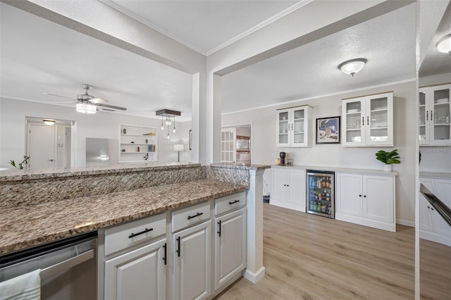 kitchen with dishwasher, wine cooler, white cabinets, ornamental molding, and light stone counters