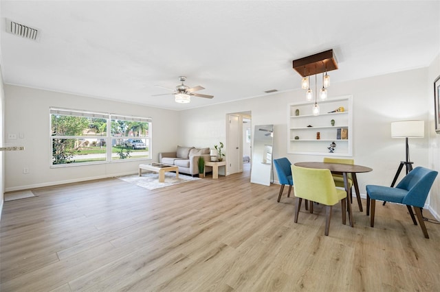 living room featuring light hardwood / wood-style flooring, ornamental molding, and ceiling fan