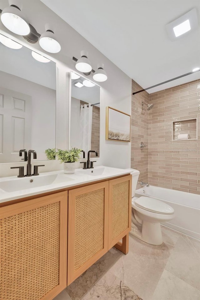 full bathroom with tiled shower / bath, vanity, and toilet