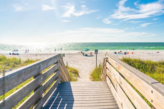 view of property's community with a beach view and a water view