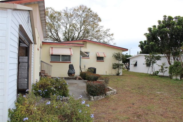 rear view of property featuring a yard and a patio area