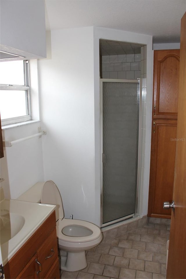 bathroom featuring vanity, toilet, and an enclosed shower