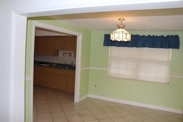 interior space featuring light tile patterned flooring, sink, and pendant lighting