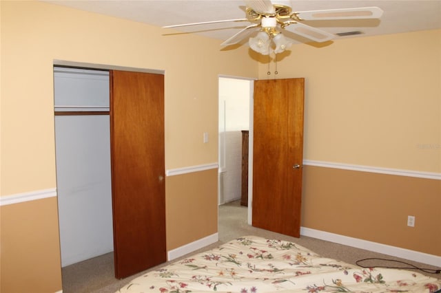 carpeted bedroom featuring ceiling fan and a closet