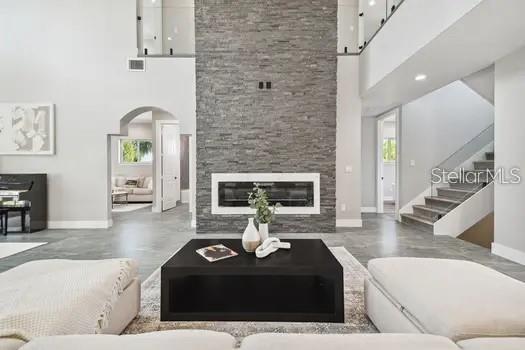 living room featuring a towering ceiling and a fireplace