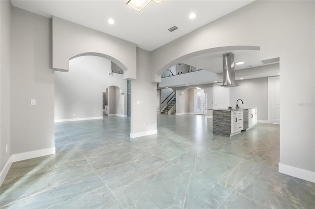 unfurnished living room featuring stairs, visible vents, and baseboards