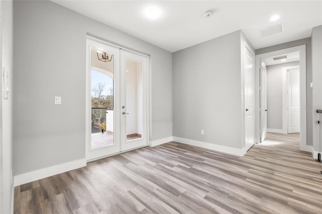 interior space with light wood finished floors, baseboards, and french doors