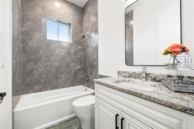 full bathroom with tiled shower / bath, vanity, and toilet