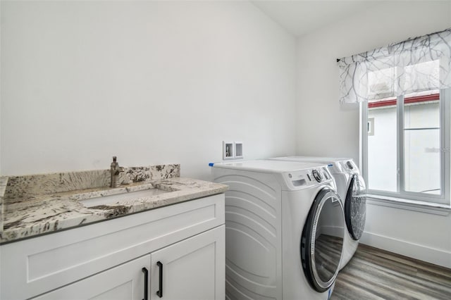 washroom featuring sink, cabinets, independent washer and dryer, and light wood-type flooring