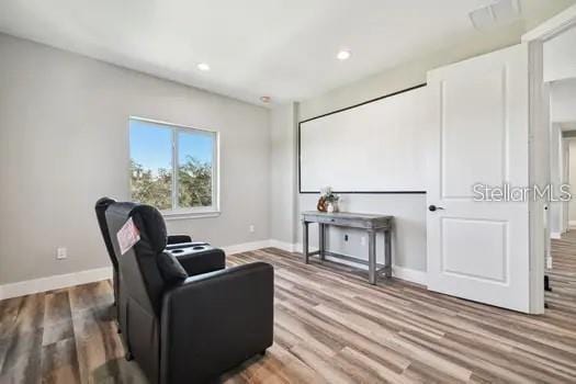 living area with recessed lighting, wood finished floors, and baseboards