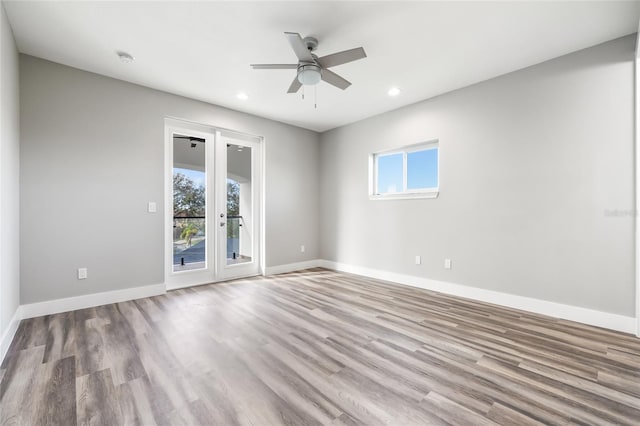 unfurnished room featuring recessed lighting, french doors, baseboards, and wood finished floors