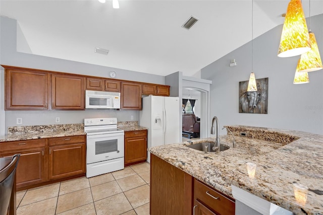 kitchen with vaulted ceiling, decorative light fixtures, sink, light stone counters, and white appliances