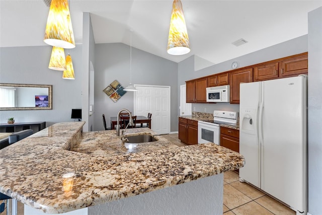 kitchen with sink, light tile patterned floors, pendant lighting, white appliances, and a kitchen island with sink