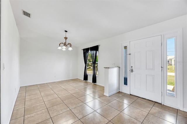 tiled foyer entrance featuring an inviting chandelier