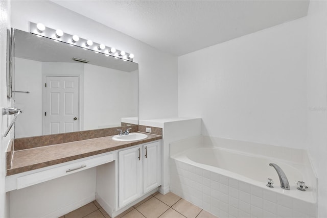 bathroom with tile patterned flooring, vanity, and tiled tub