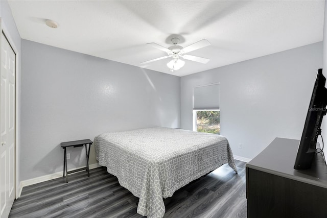 bedroom with dark wood-type flooring, ceiling fan, and a closet