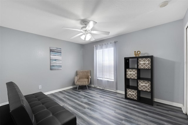 living area with dark hardwood / wood-style floors and ceiling fan