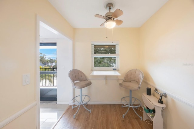 living area featuring light hardwood / wood-style floors and ceiling fan