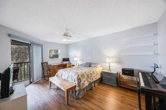 bedroom featuring ceiling fan, hardwood / wood-style floors, and a textured ceiling