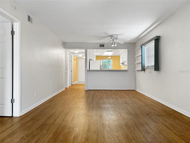 11485 Oakhurst Rd Unit A301, Largo, FL 33774 - unfurnished living room with wood finished floors, a textured ceiling, and ceiling fan