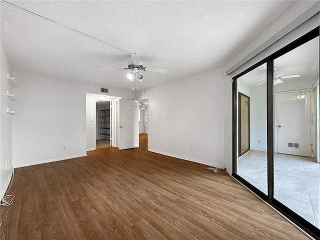 11485 Oakhurst Rd Unit A301, Largo, FL 33774 - unfurnished bedroom with wood finished floors, a textured ceiling, access to exterior, and a ceiling fan