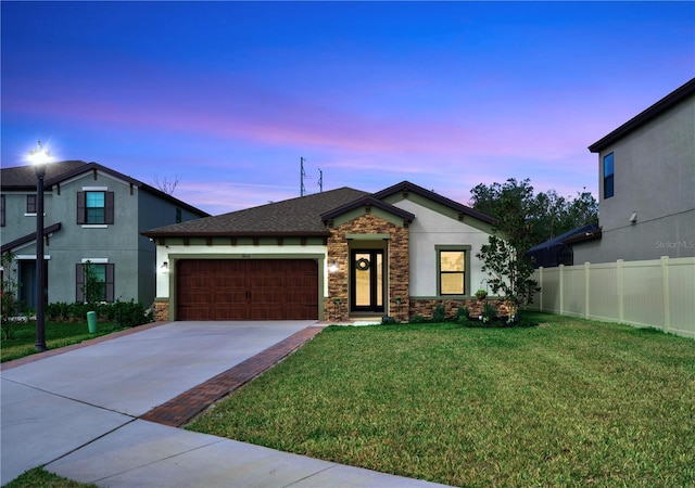 view of front of home featuring a garage and a lawn