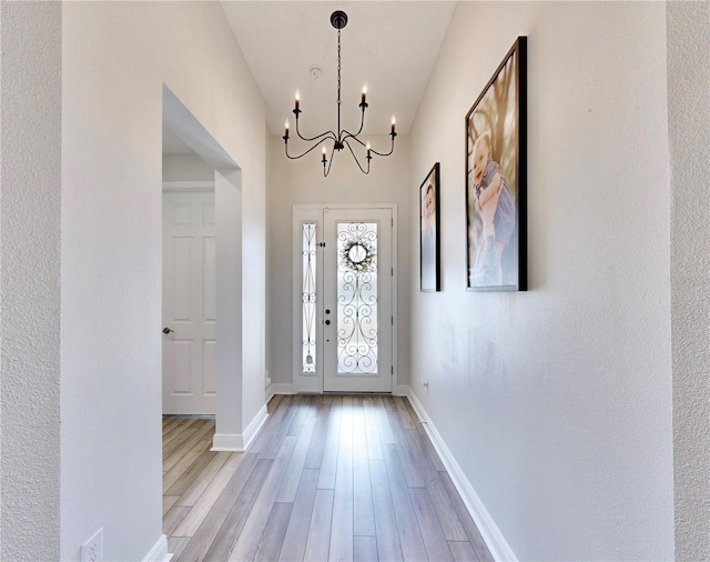 foyer with light hardwood / wood-style floors and a chandelier