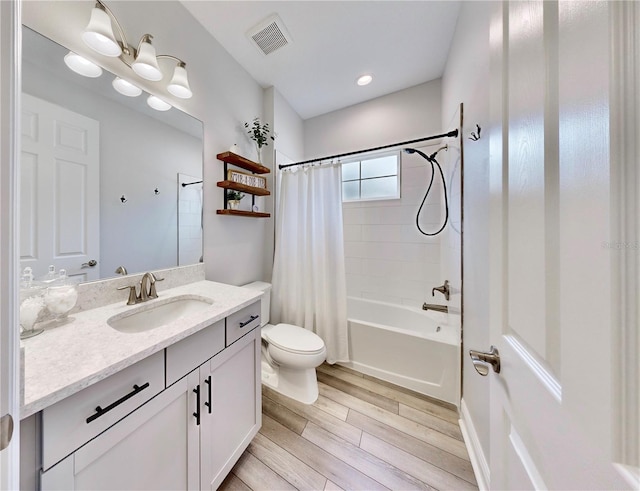 full bathroom featuring shower / tub combo with curtain, hardwood / wood-style floors, vanity, and toilet