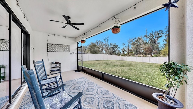 sunroom / solarium featuring ceiling fan