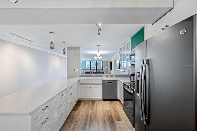 kitchen featuring sink, white cabinetry, light hardwood / wood-style flooring, appliances with stainless steel finishes, and kitchen peninsula