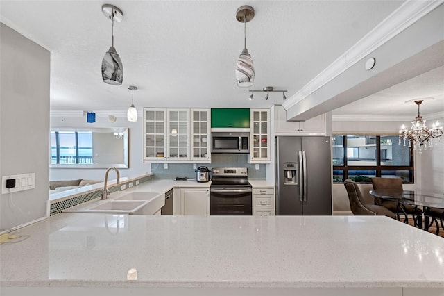 kitchen with pendant lighting, sink, white cabinets, and appliances with stainless steel finishes