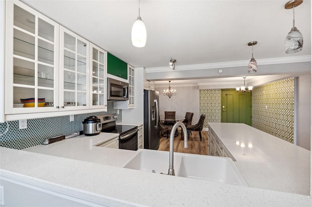 kitchen with an inviting chandelier, hanging light fixtures, sink, and appliances with stainless steel finishes