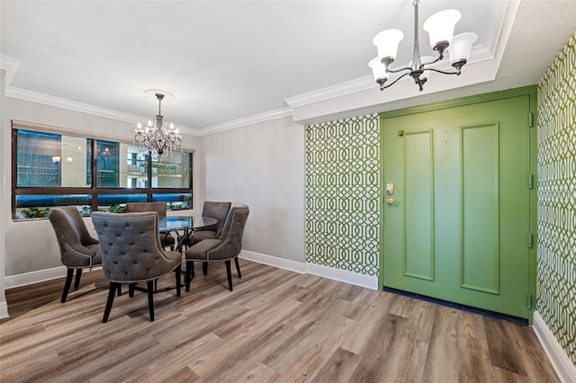 dining room with crown molding, a notable chandelier, and light hardwood / wood-style floors