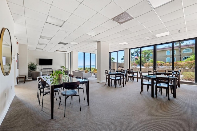 dining area featuring a drop ceiling and floor to ceiling windows