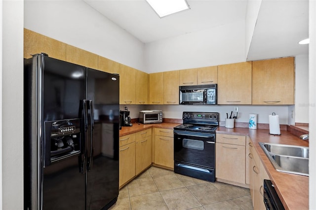 kitchen featuring light brown cabinetry, sink, and black appliances