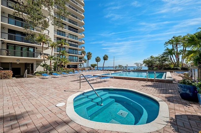 view of pool featuring a community hot tub and a patio area