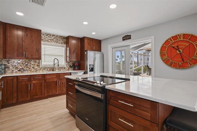 kitchen featuring tasteful backsplash, sink, plenty of natural light, and appliances with stainless steel finishes