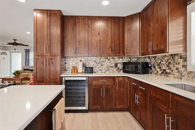 kitchen featuring wine cooler, ceiling fan, light hardwood / wood-style floors, and decorative backsplash