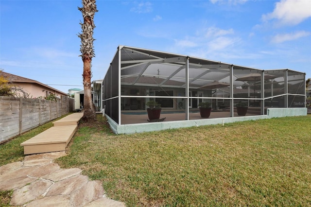 back of house featuring a swimming pool, a lawn, and glass enclosure