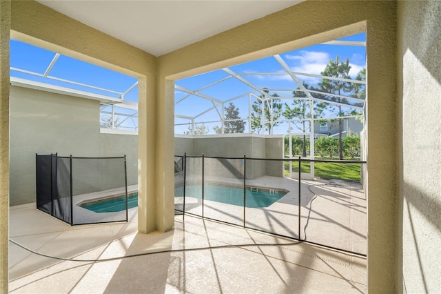 view of pool with a patio area and glass enclosure